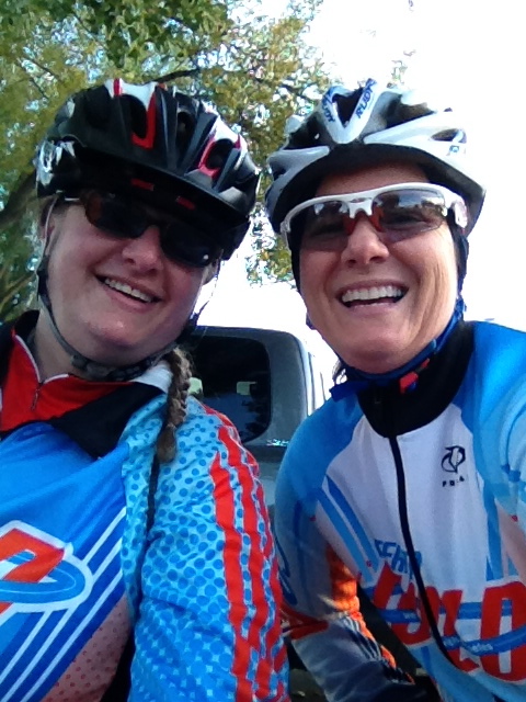 Two women in biking helmets and windbreakers